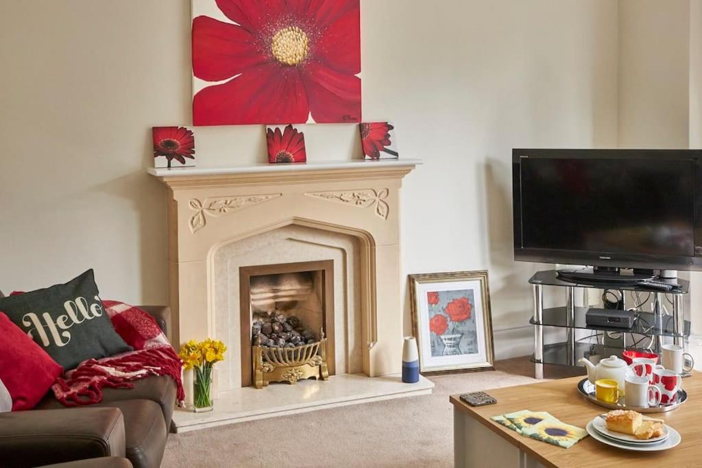 a living room with a fireplace and a flat screen tv at Comfy big 7 bedroom townhouse in Harrogate