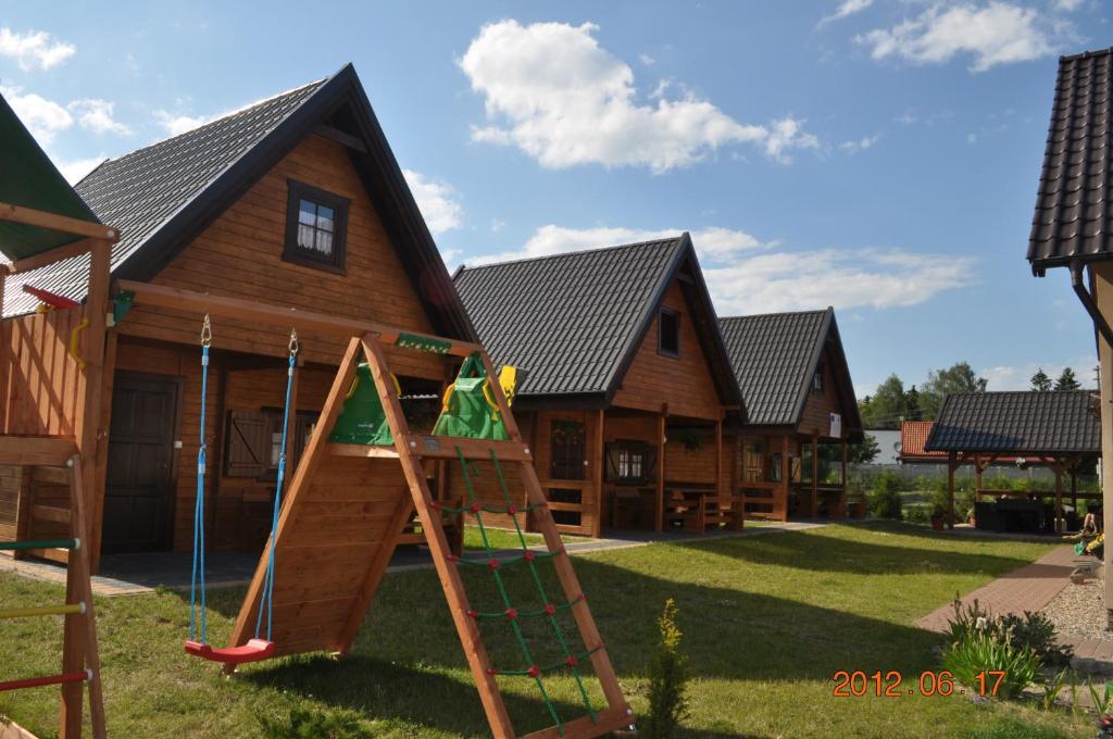 a playground in front of a log house at Domki Letniskowe in Sztutowo
