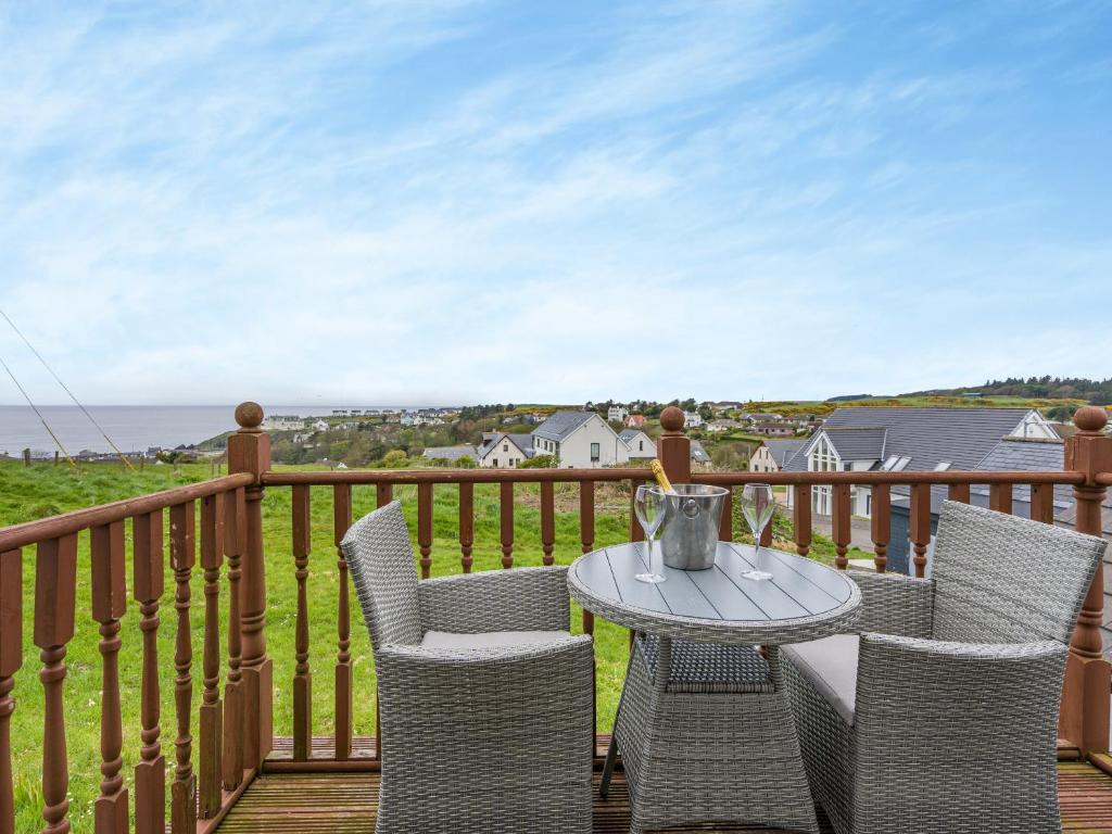 un patio con mesa y sillas en una terraza en Ben Ma Cree, en Portpatrick