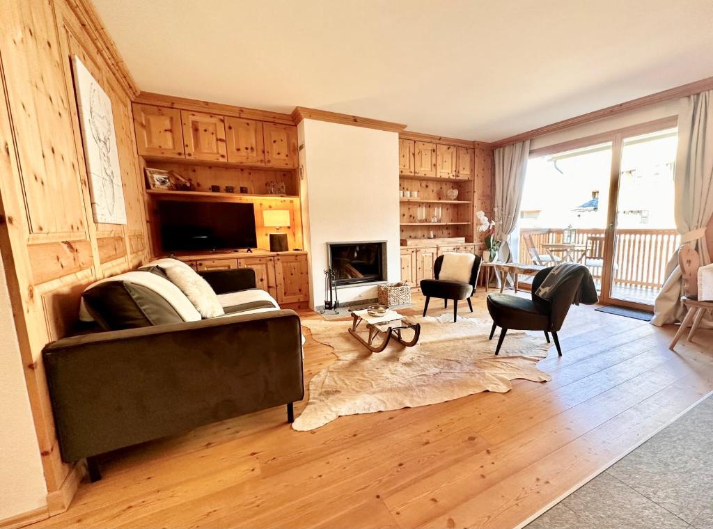 ein Wohnzimmer mit einem Sofa und einem Tisch in der Unterkunft Cà Val Forno - Vacanze con stile in Maloja