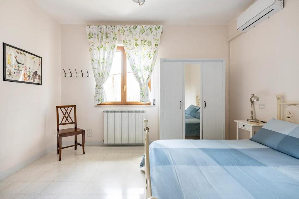 a white bedroom with a blue bed and a window at B&B Vigna del Duca in Grassano