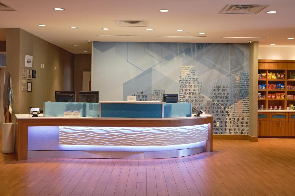 a waiting area in a library with a large wall at SpringHill Suites by Marriott Dallas Lewisville in Lewisville
