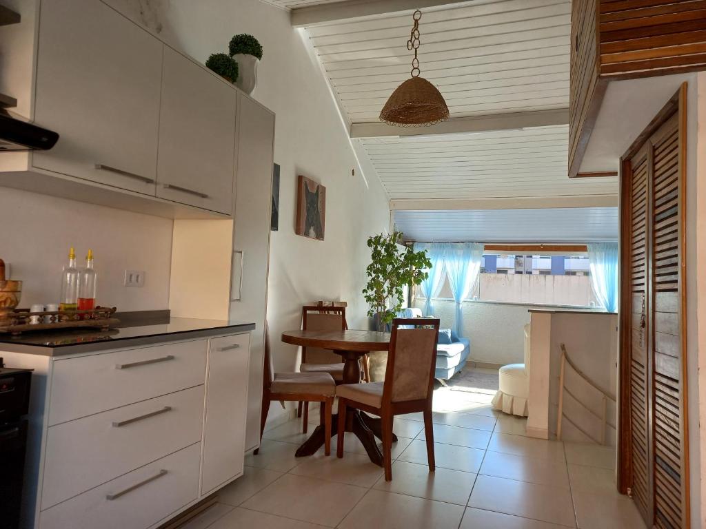 a kitchen with a table and a dining room at Casa Oceano Azul in Guarujá