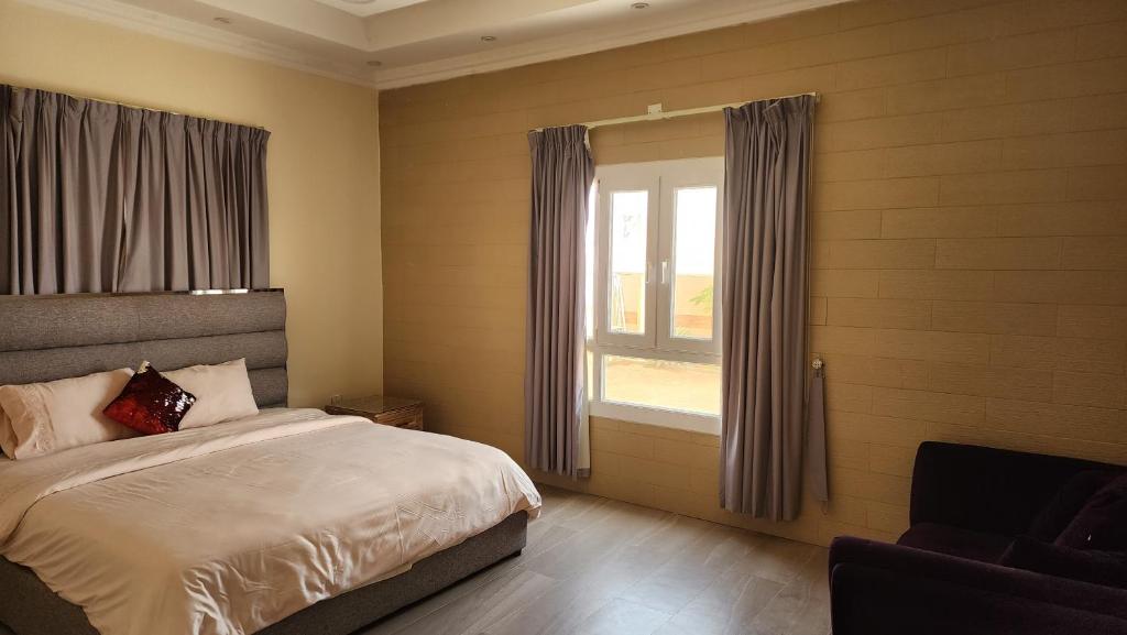 Un dormitorio con una cama grande y una ventana en 4 bedroom Yasmin Garden, en Barka