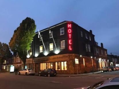 un bâtiment avec un panneau de néon sur son côté dans l'établissement Hotels 24-7 - The Old Victoria Hotel, à Newport