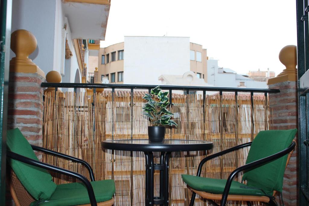 une table avec des chaises et une plante en pot sur un balcon dans l'établissement SUITE DEL MAR II, à Torre del Mar