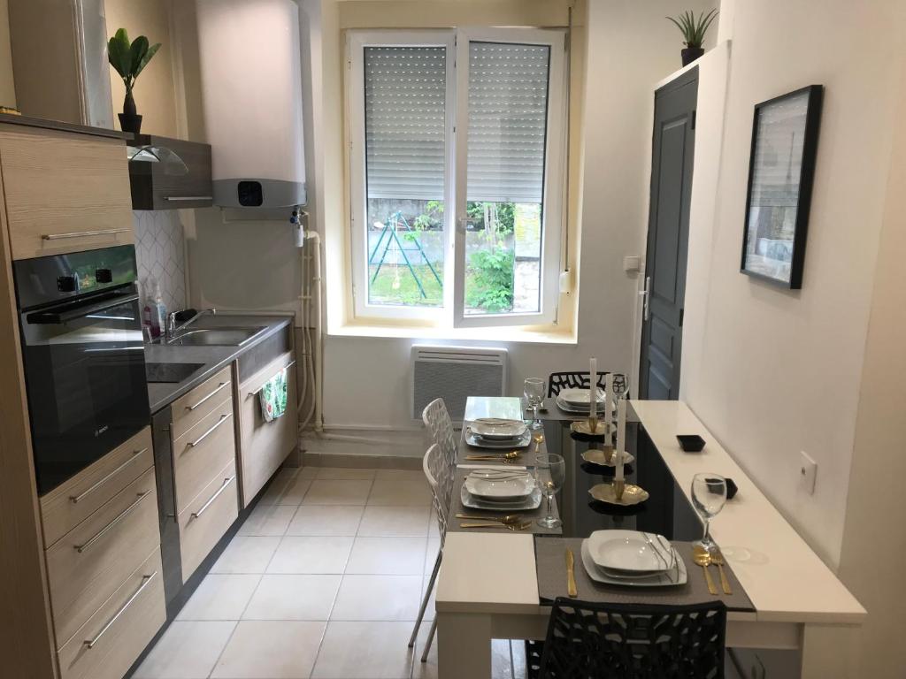 a kitchen with a table with chairs and a window at Sci ZLR in Saint-Étienne