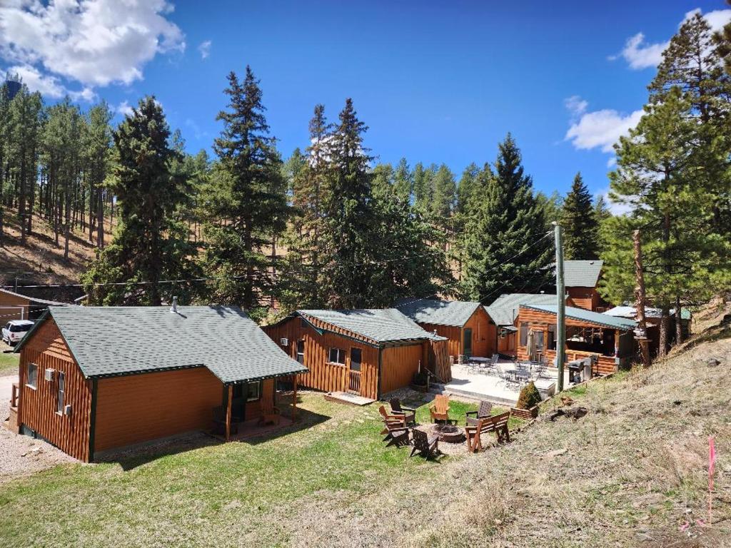 a group of wooden cabins in a forest at Allen Gulch Cabins in Hill City