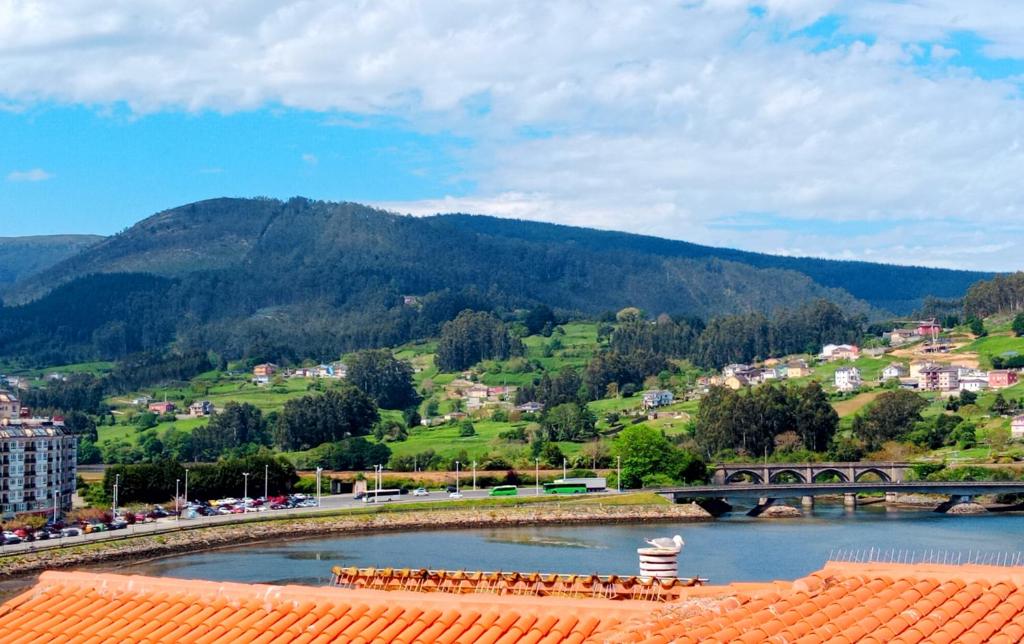 Blick auf einen Fluss mit einer Brücke und einem Berg in der Unterkunft Atico en La Ría in Vivero