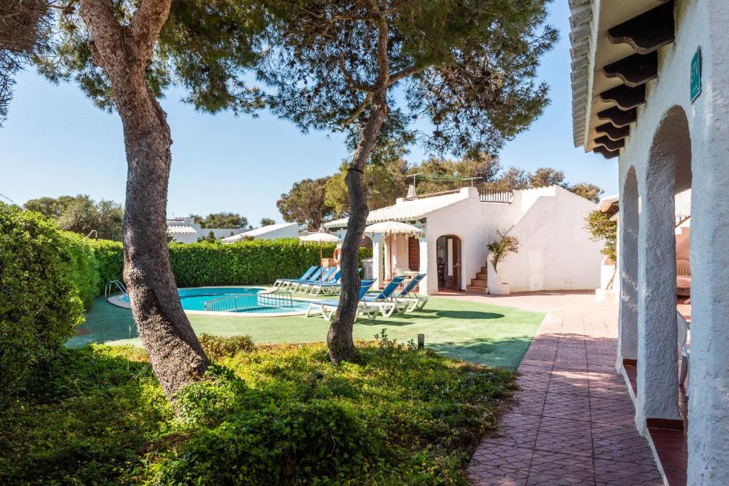 a villa with a swimming pool and trees at Apartamentos Menorca MONSINES 13C By Mauter Villas in Cala Blanca