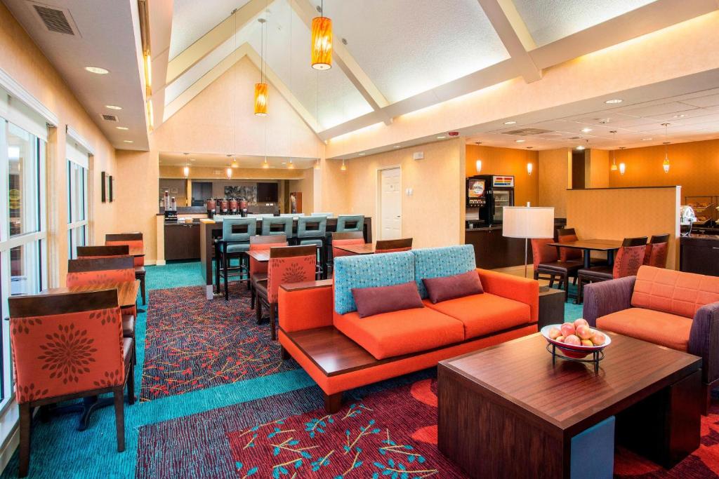 a hotel lobby with orange furniture and a bar at Residence Inn Topeka in Topeka