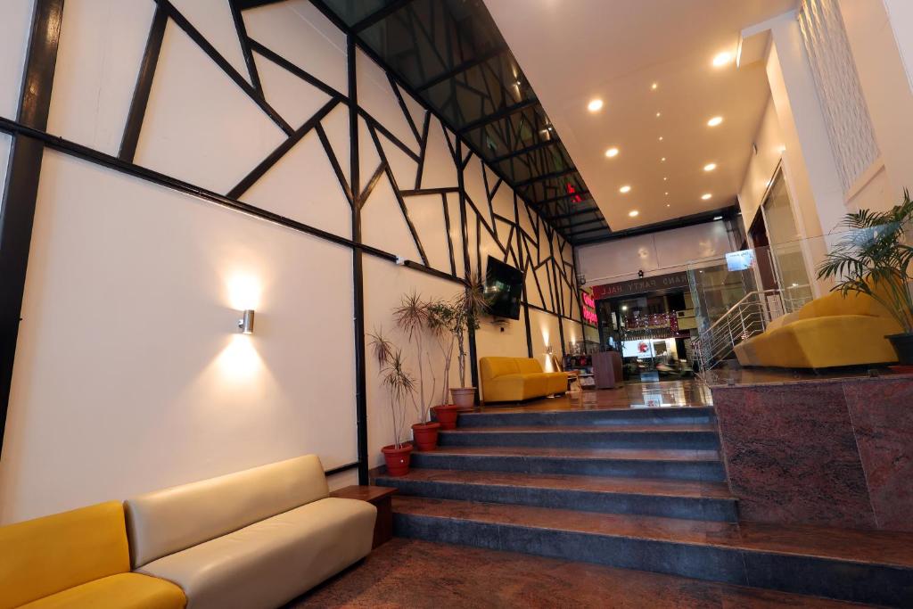 a lobby with a couch and stairs in a building at Grand Regency Rajajinagar, Iskcon Temple - WTC in Bangalore