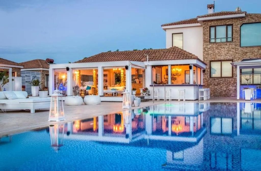 a house with a pool in front of it at Cape Serenity Mansion in Ayia Napa