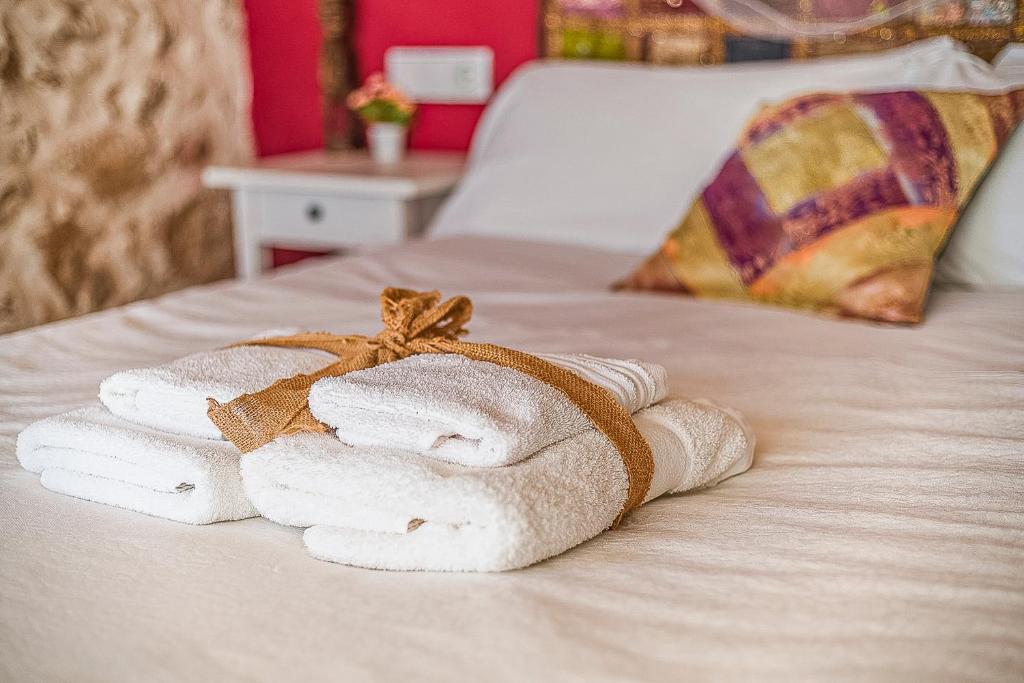 una pila de toallas sentadas encima de una cama en El Pajar de Tía María, en Casas del Castañar