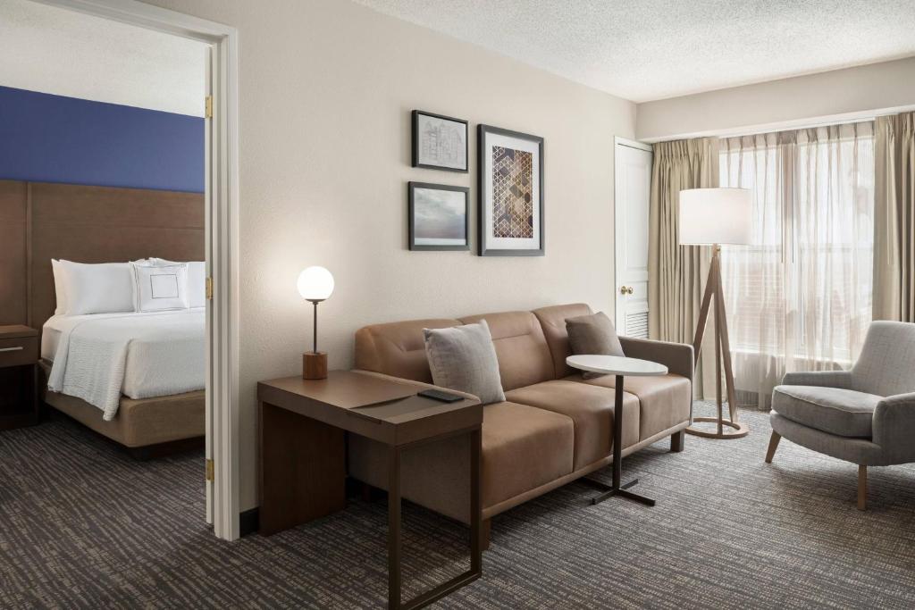 ein Hotelzimmer mit einem Sofa und einem Bett in der Unterkunft Residence Inn Kansas City Independence in Independence