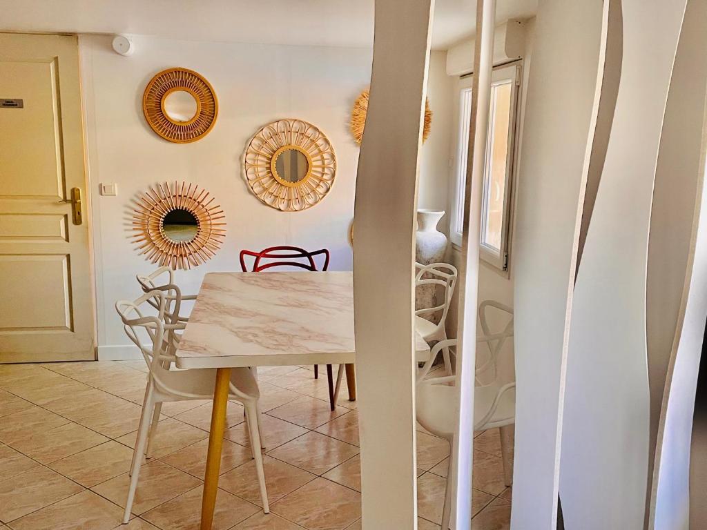 a dining room with a table and chairs and mirrors at Appartement 120m2 dans maison avec piscine in Boissy-lʼAillerie