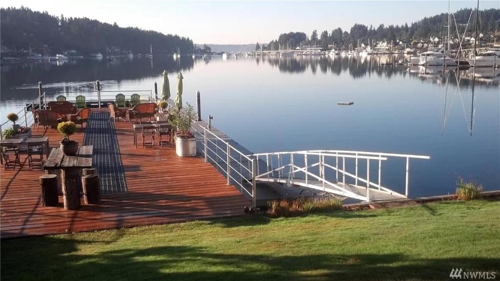 eine Anlegestelle mit einem Tisch und Stühlen auf dem Wasser in der Unterkunft Waterfront Inn in Gig Harbor