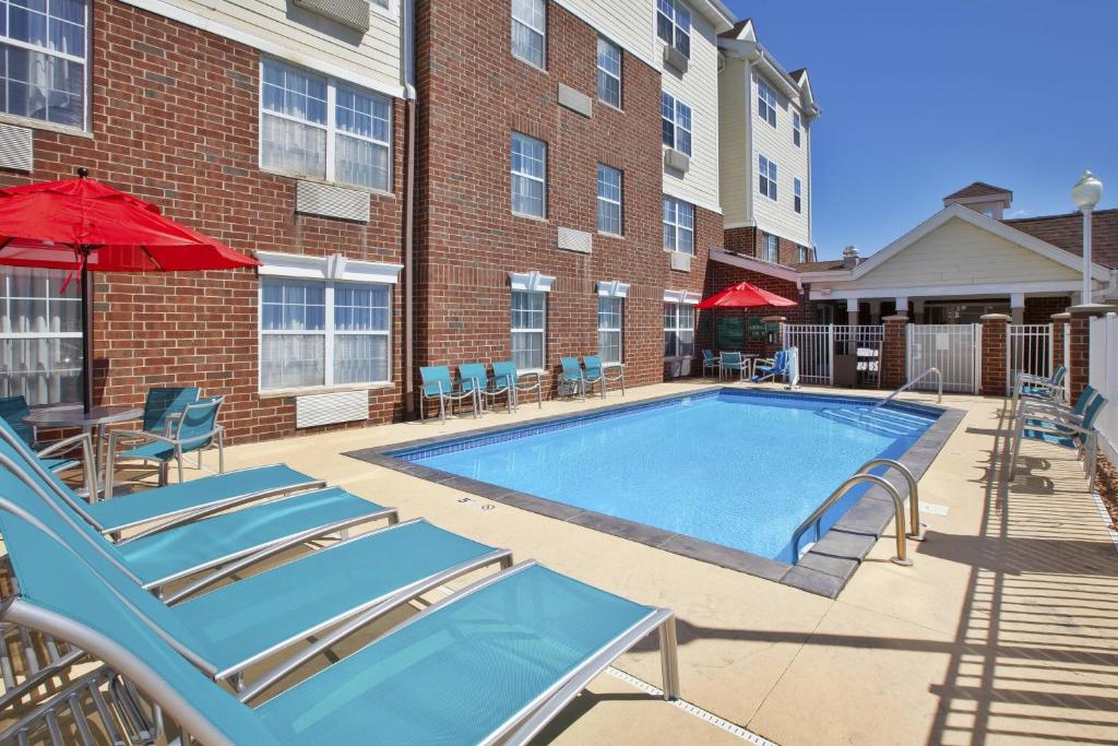 a swimming pool in front of a building with chairs and umbrellas at TownePlace Suites Minneapolis-St. Paul Airport/Eagan in Eagan