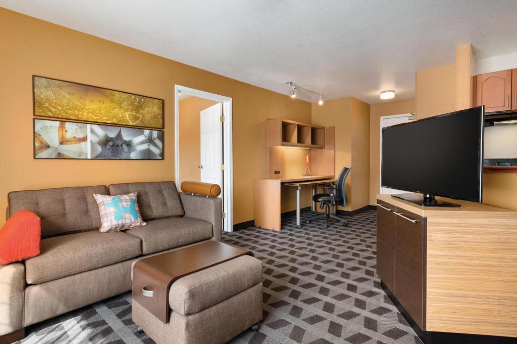 a living room with a couch and a flat screen tv at TownePlace Suites by Marriott Denver Downtown in Denver