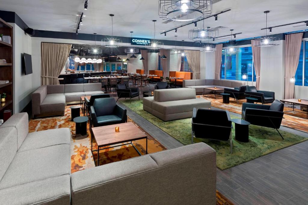 a lobby with couches and tables and a bar at Courtyard Fort Wayne Downtown at Grand Wayne Convention Center in Fort Wayne