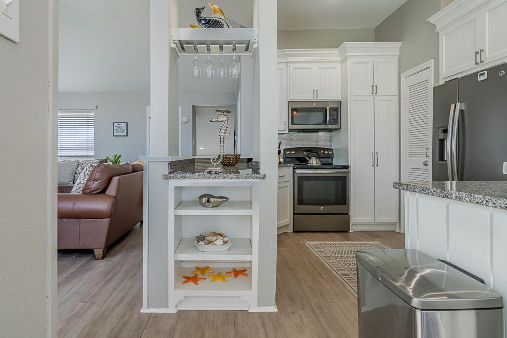 a kitchen with white cabinets and a counter top at Hot Tub - Ocean Views - Steps to Private Beach - Quiet Location in Galveston