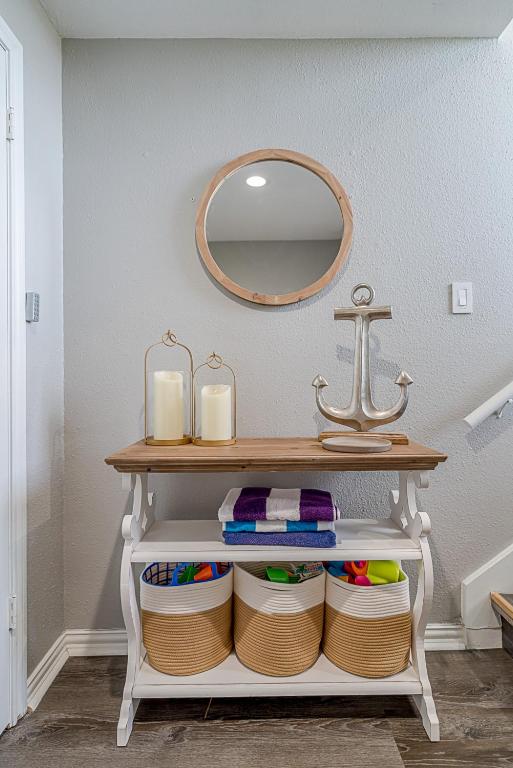 a bathroom with a mirror and a shelf with towels at Hot Tub - Ocean Views - Steps to Private Beach - Quiet Location in Galveston