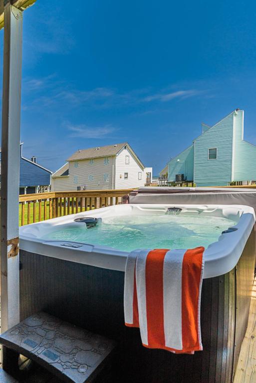 a hot tub on a deck with a towel on it at Hot Tub - Ocean Views - Steps to Private Beach - Quiet Location in Galveston