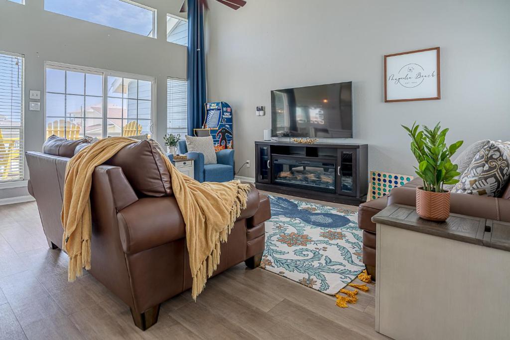 a living room with two couches and a tv at Hot Tub - Ocean Views - Steps to Private Beach - Quiet Location in Galveston