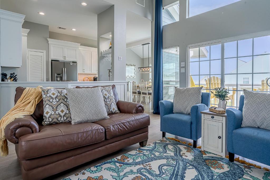 sala de estar con sofá y 2 sillas azules en Hot Tub - Ocean Views - Steps to Private Beach - Quiet Location, en Galveston