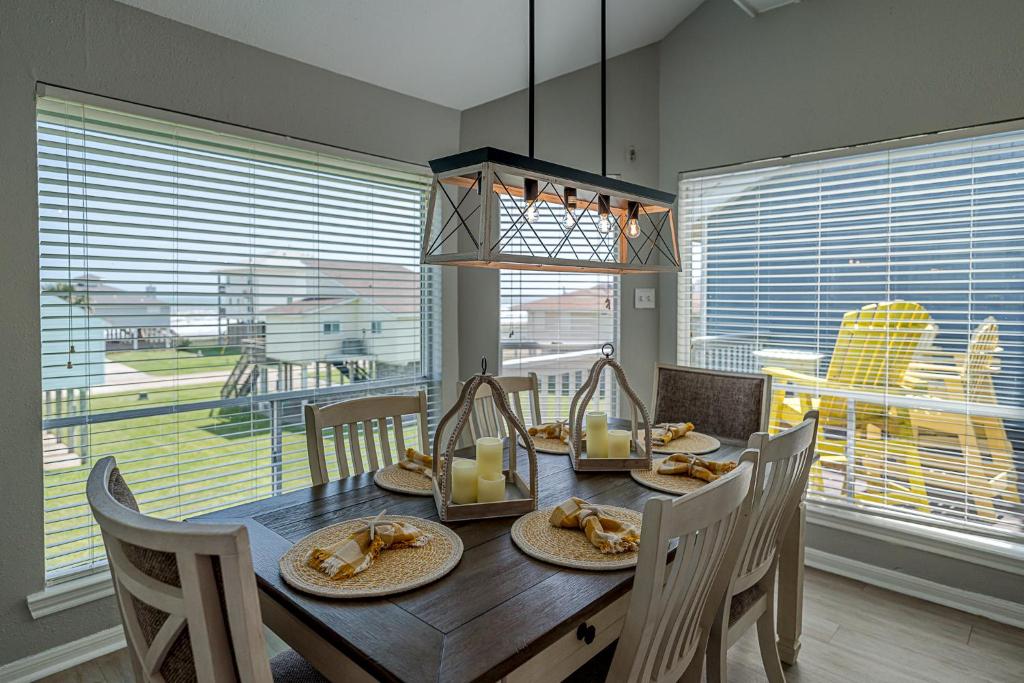 a dining room table with plates of food on it at Hot Tub - Ocean Views - Steps to Private Beach - Quiet Location in Galveston