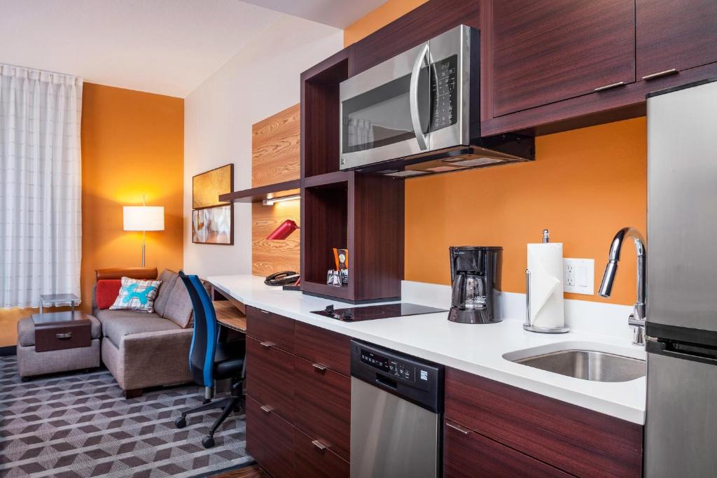 a kitchen with a sink and a living room at TownePlace Suites by Marriott Orlando Altamonte Springs/Maitland in Orlando