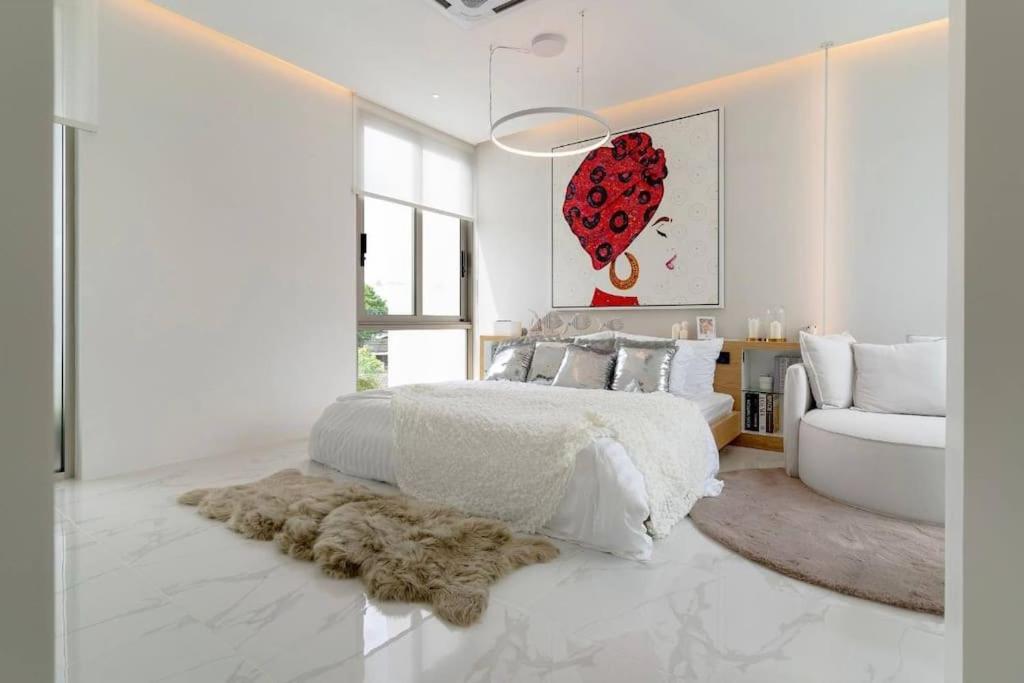 a white bedroom with a large bed and a couch at The Residence by Andaman Phuket Free Airoport Pick up from 7 days in Ban Mut Dok Khao