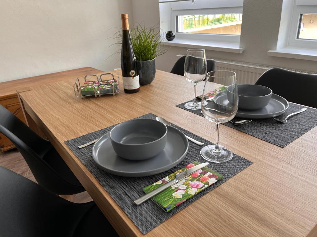 un tavolo in legno con due piatti e bicchieri da vino di 109 a Zell an der Mosel