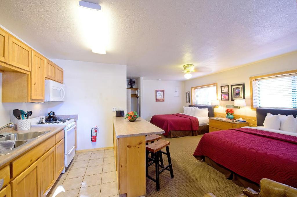 ein Zimmer mit einer Küche und ein Schlafzimmer mit 2 Betten in der Unterkunft Sitzmark Sports Lodge in Red River
