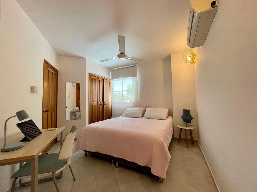 1 dormitorio con cama, escritorio, mesa y sillas en A pasos de la playa! Acogedor apartamento en Bello Horizonte con Balcón I WiFi, en Playa Dormida