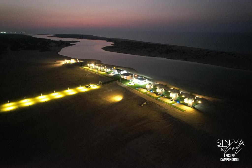 an aerial view of a river at night with lights at Palette Siniya Island Resorts in Umm Al Quwain