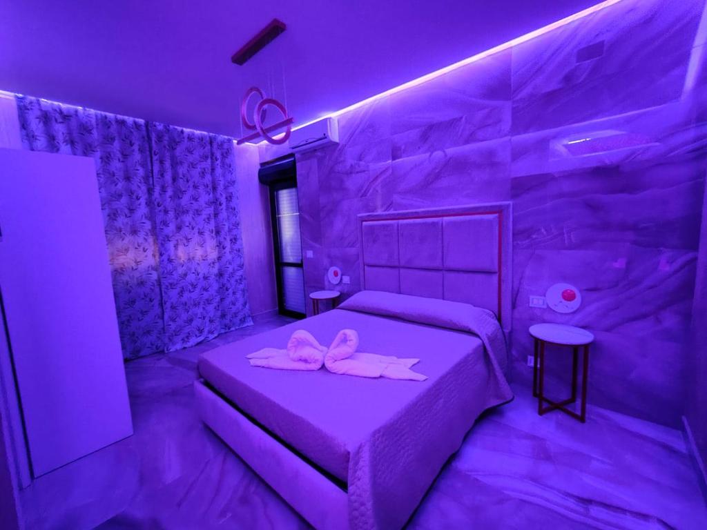 a purple bedroom with a bed with two pink bows on it at B&B MaisonAlysie in Foggia