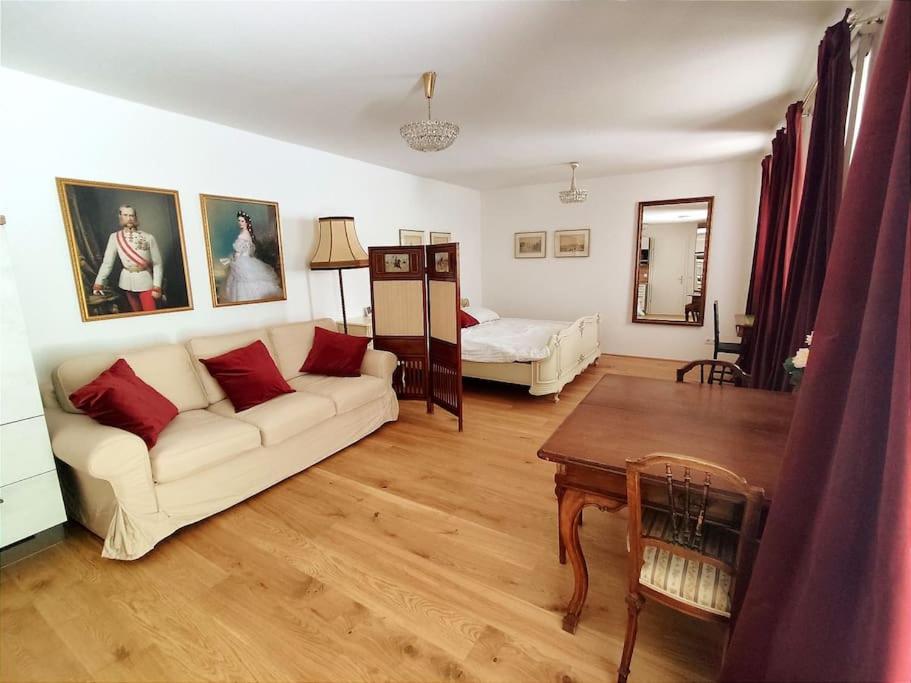 uma sala de estar com um sofá e uma cama em Imperial Sisi Residence-Concept Style Apartment em Viena