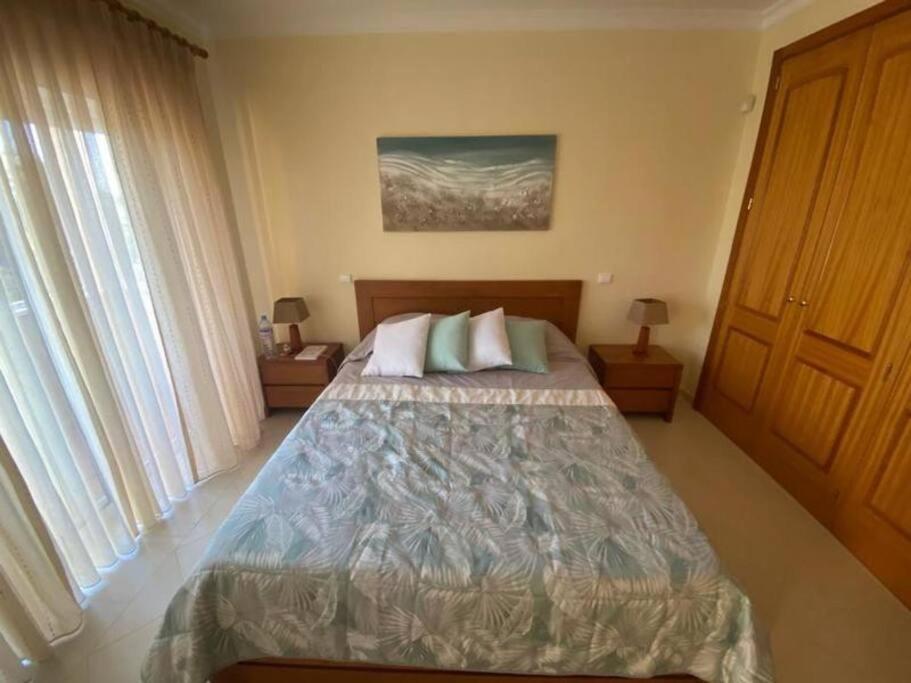 1 dormitorio con 1 cama grande y 2 ventanas en Quinta da Boa Nova - Cheerful and spacious 2-bedroom duplex, en Estômbar