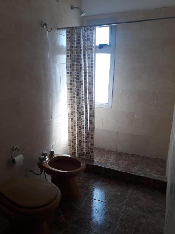 a bathroom with a toilet and a window at Alojamiento Concordia in Concordia