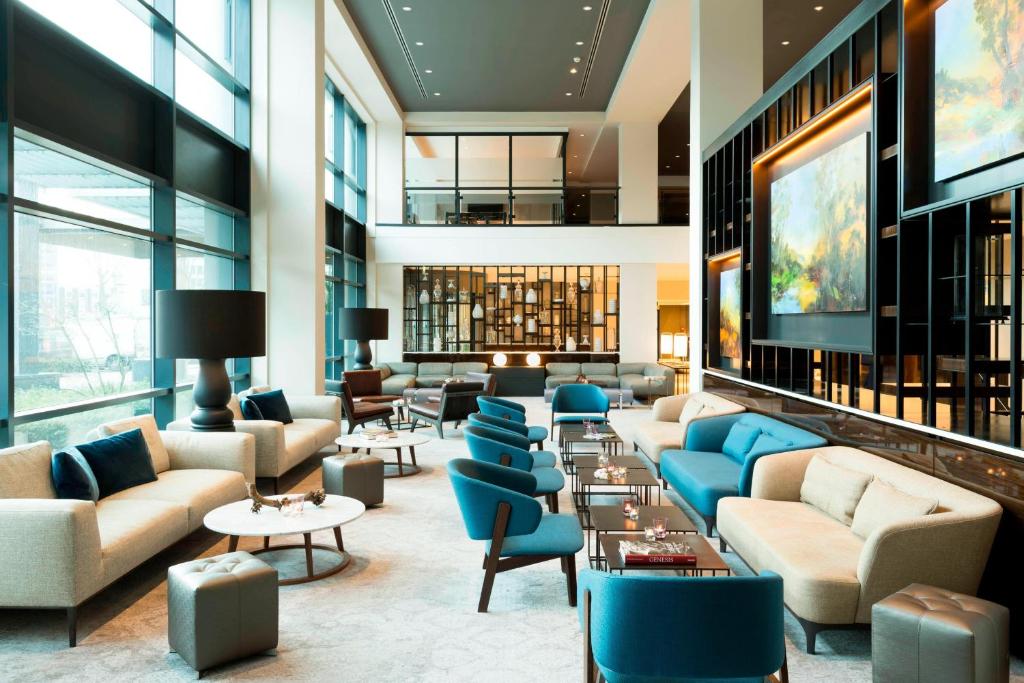 a lobby with couches and chairs and tables at Marriott Hotel The Hague in The Hague