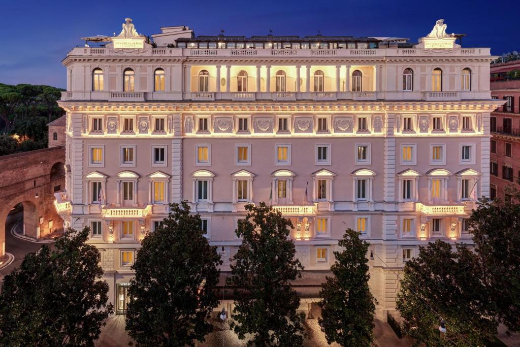 ローマにあるマリオット グランド ホテル フローラの目の前に木々が植えられた白い大きな建物