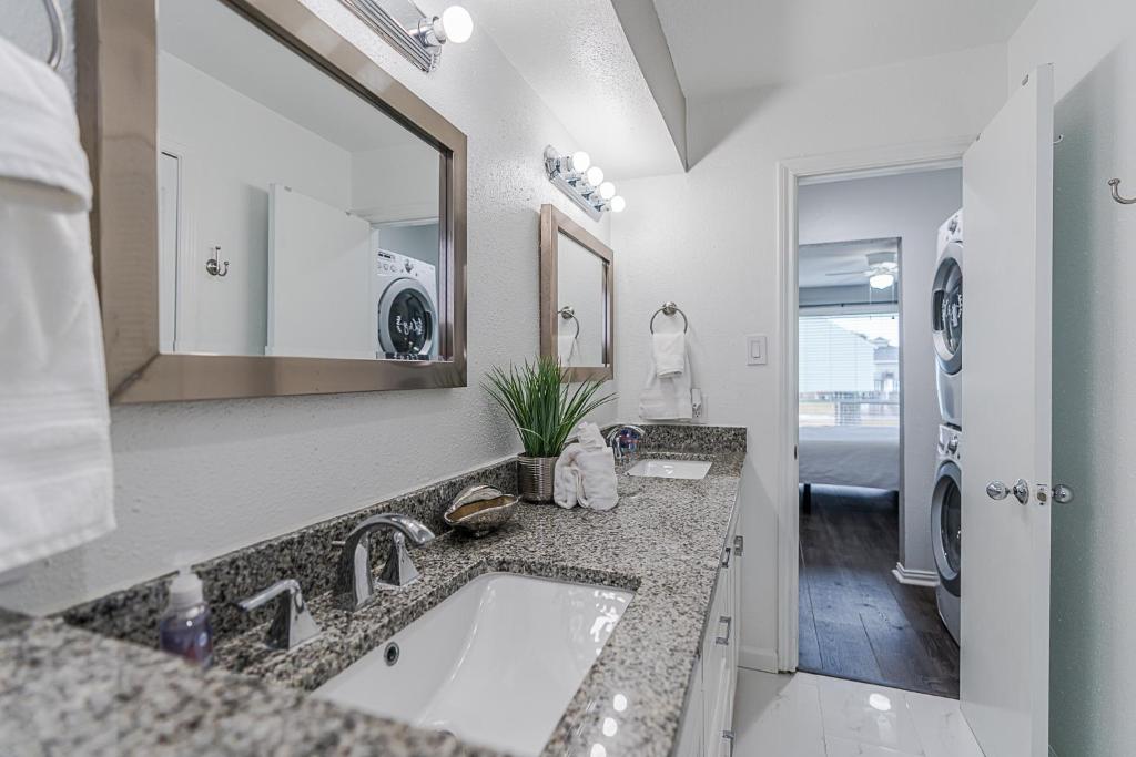 a bathroom with a sink and a mirror at Hot Tub - Ocean Views - Steps to Private Beach - Quiet Location in Galveston