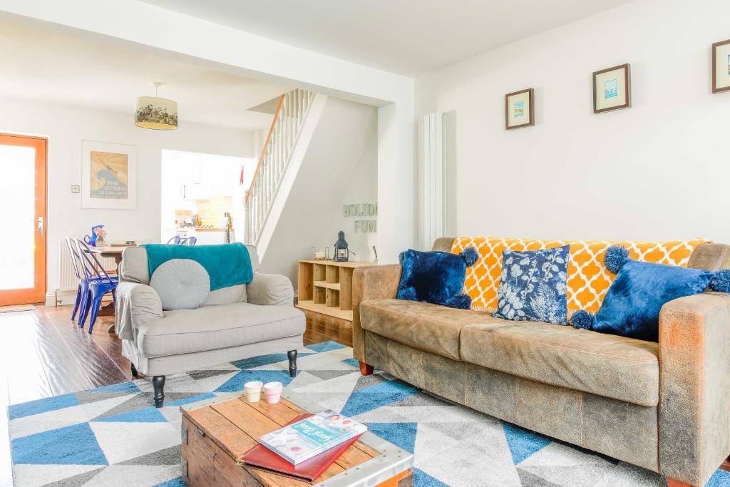 ein Wohnzimmer mit einem Sofa und einem Stuhl in der Unterkunft Shell Cottage in Whitstable