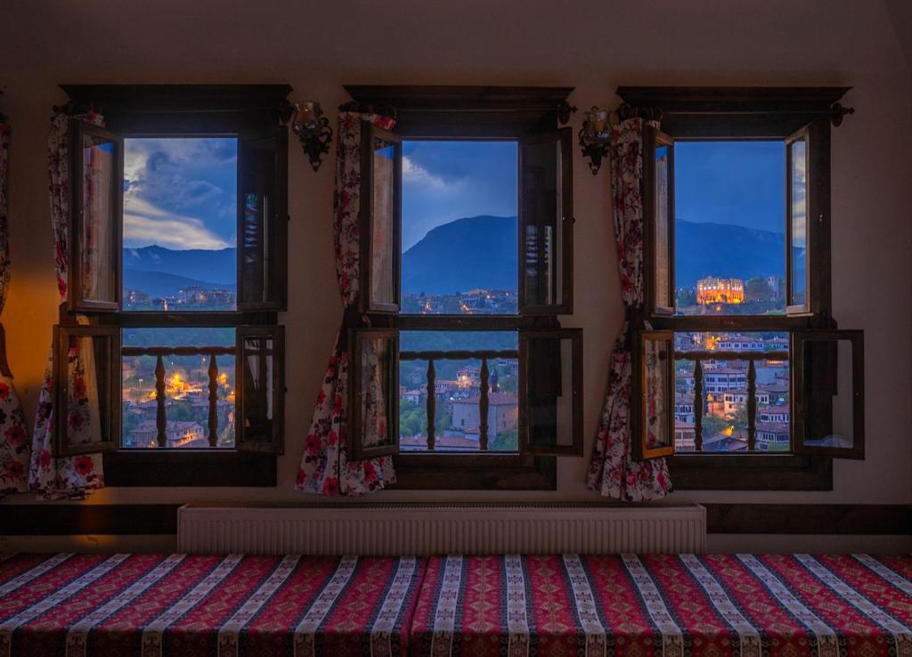 a room with three windows with a view of a city at Gunes Konak Otel Safranbolu in Safranbolu