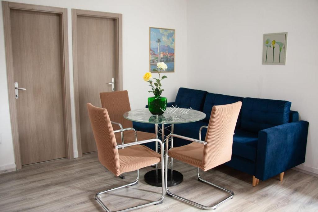 a dining room with a blue couch and a table and chairs at Amber in the centar in Kaštela