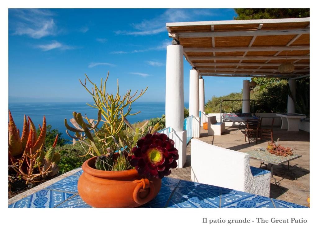 un jarrón con flores sentado en una mesa junto al océano en Villa Donatella, en Leni