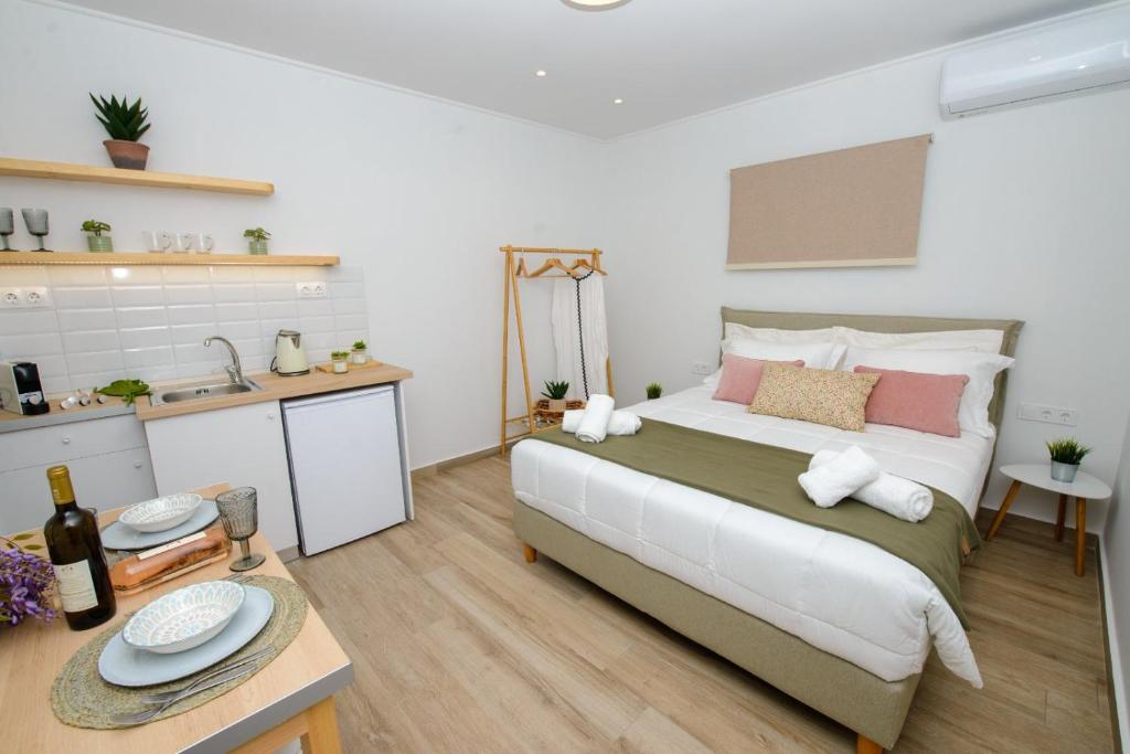 a bedroom with a large bed and a kitchen at Kumquat studio Gouvia in Gouvia