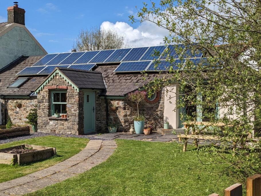 a house with solar panels on the roof at Cosy Cottage Crundale 