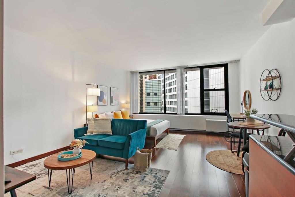 a living room with a blue couch and a bed at Stylish Studio with Full Kitchen & Modern Bathroom - Chestnut 15C in Chicago